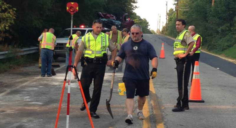 Workers and deputy sheriffs clear the scene of a double-fatal, head-on accident on Riverside Drive in Vassalboro today.