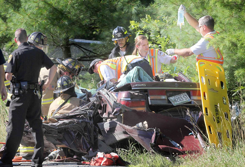 Rescue officials work to remove a female occupant of a vehicle involved in a head-on collison on China Road in Winslow on Wednesday afternoon.