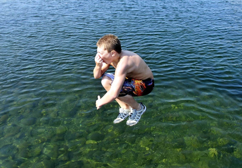 Caleb Sinkinson-Brown does a cannonball dive into Clearwater Lake in Industry on a warm Monday.
