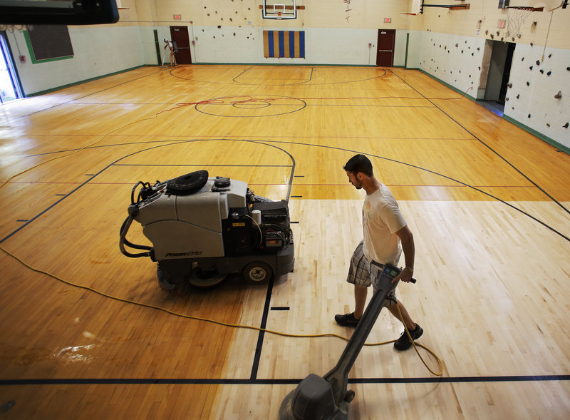 Paul Keef, foreground, and Jason Rousseau, background, of Clean-O-Rama, buff the gymnasium floor at King Middle School Wednesday, August 21, 2013, in preparation for the start of the upcoming school year.