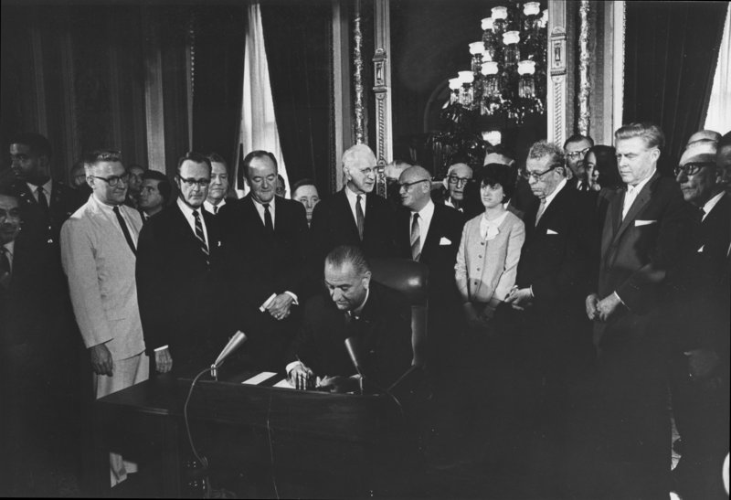 President Lyndon Johnson signs the Voting Rights Act of 1965, two years after the March on Washington, surrounded by members of Congress. At left behind the man in the light-colored suit, looking away from LBJ, is associate press secretary Harold Pachios of Cape Elizabeth, who later was a founding partner at a Portland law firm.