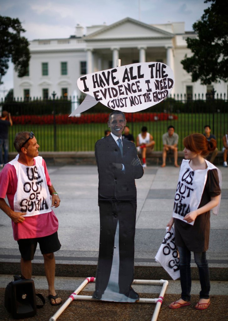 Protesters against U.S. military intervention in Syria stand beside a cutout of President Obama at a rally Thursday outside the White House. Skeptics want solid evidence linking the Assad regime to the use of chemical weapons.