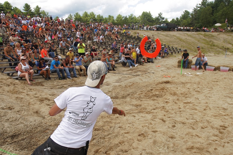 Corey Phillips of Chesterville competes in the toilet seat toss in front of a crowd.