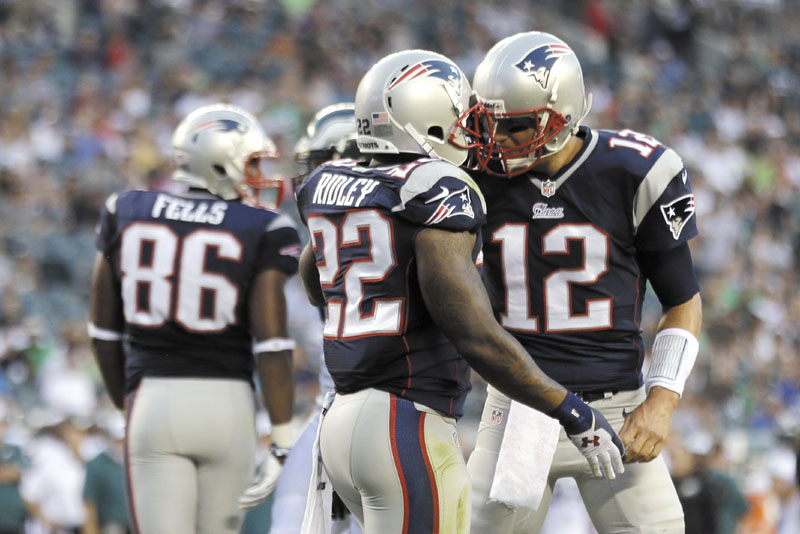 GOOD START: New England Patriots quarterback Tom Brady (12) and running back Stevan Ridley (22) celebrate after Ridley scored a touchdown during the first half of the Patriots’ 31-22 preseason win over the Philadelphia Eagles on Friday in Philadelphia. Ridley rushed eight times for 92 yards, while Brady completed seven of eight passes for 65 yards.