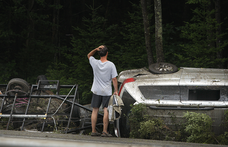 A man surveys the damage to a vehicle that crashed on Interstate 295 at mile 25 northbound in Freeport on Friday.