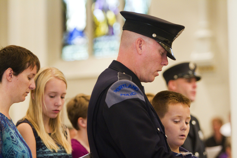 Portland Police Officer Kevin Haley and his son William, 9, participate in the Blue Mass at the Cathedral of the Immaculate Conception in Portland on Sunday. Hundreds of local, state and federal law enforcement officers, firefighters and emergency personnel were recognized for their dedication and self-sacrifice at the annual Mass.