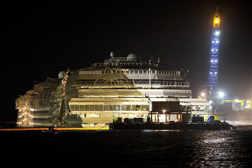 The Costa Concordia is seen after it was lifted upright, on the Tuscan Island of Giglio, Italy, early Tuesday morning. The crippled cruise ship was pulled completely upright early Tuesday after a complicated, 19-hour operation to wrench it from its side where it capsized last year off Tuscany, with officials declaring it a "perfect" end to a daring and unprecedented engineering feat.