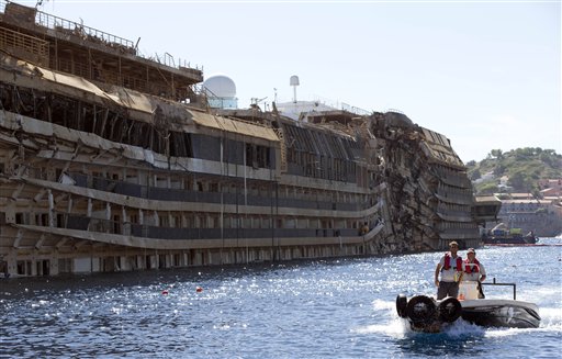 People take a small boat past the damaged side of he Costa Concordia on the Tuscan Island of Giglio, Italy, last week. The crippled cruise ship was pulled completely upright early last Tuesday after a complicated, 19-hour operation.