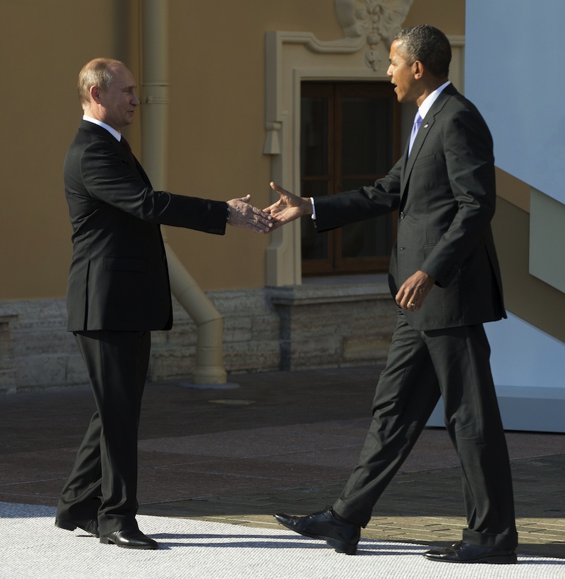 President Barack Obama reaches to shakes hands with Russia's President Vladimir Putin during arrivals for the G-20 summit at the Konstantin Palace in St. Petersburg, Russia on Thursday, Sept. 5, 2013. (AP Photo/Pablo Martinez Monsivais/Pool)