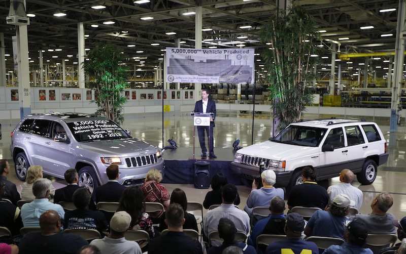 In this Aug. 13, 2013 file photo, Scott Garberding, senior vice president of manufacturing for Chrysler Group LLC stands between a 1992 Grand Cherokee, right, and the automaker's 5,000,000th vehicle produced at the Jefferson North Assembly Plant in Detroit. Chrysler's U.S. sales rose 12 percent in August as strong truck sales pushed the company to its best month in six years. (AP Photo/Carlos Osorio, File)