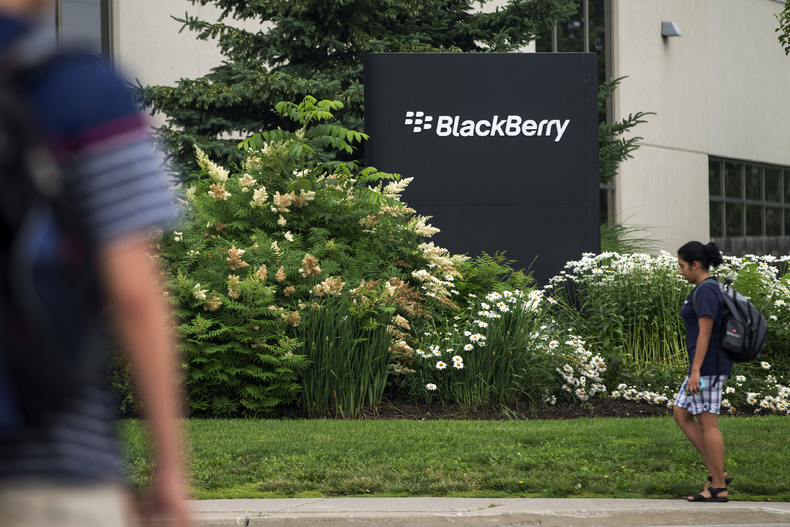 Pedestrians walk near BlackBerry's headquarters in Waterloo, Ontario, in July. BlackBerry said Friday that it will lay off 4,500 employees, or 40 percent of its global workforce and is announcing a nearly $1 billion second-quarter loss in a surprise early release of earnings.