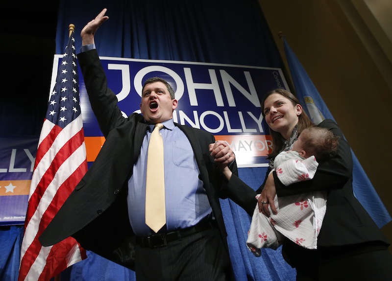 Boston Mayoral hopeful John Connolly waves to supporters with his wife, Meg, and their baby, Mary Kate, at his primary election night headquarters in Boston, Tuesday, Sept. 24, 2013.