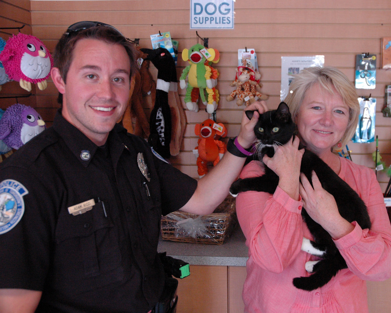 Buxton police Officer Adam Ricci pets Echo, one of many animals he has helped rescue, as Betsy Murphy, executive director of the Animal Refuge League of Greater Portland, holds the cat in the lobby of the Westbrook shelter. Buxton animals rescued