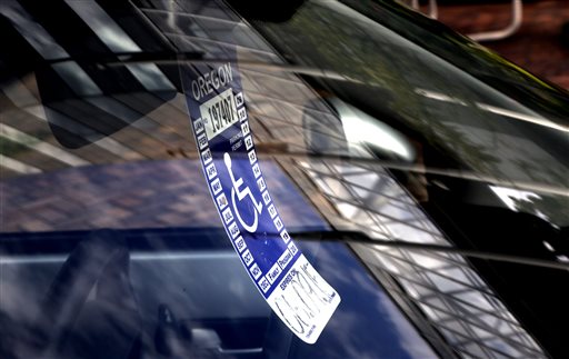 A handicapped parking tag hangs from the rearview mirror of a car parked at a metered parking spot in Portland, Ore., where it's common to find blocks in which there are more cars with placards than without.