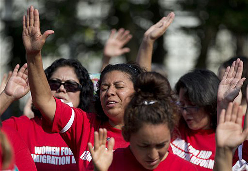 Women recite the "Oath for a House United" as they gather before blocking an intersection outside the House of Representatives on Capitol Hill in Washington on Thursday to protest Congress' inaction on immigration reform.