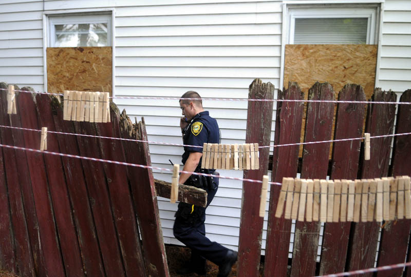 Augusta Police Officer Niko Hample walks the perimeter of an apartment building Thursday on Jefferson Street that was closed by the City of Augusta.