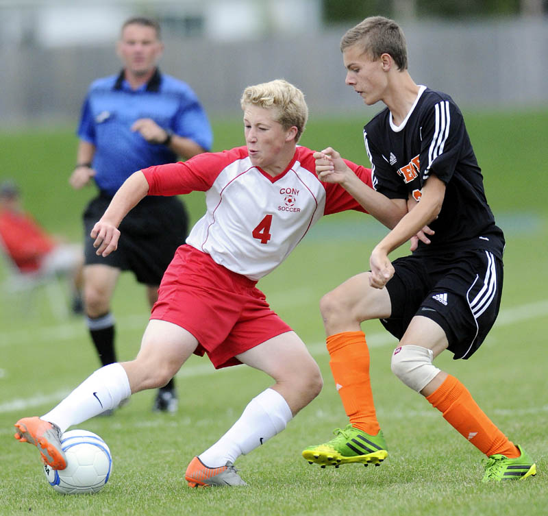 DRIVE: Cony High School's Conner Perry, left, moves the ball away from Brewer High School's Gehrig White during a soccer game Tuesday in Augusta.