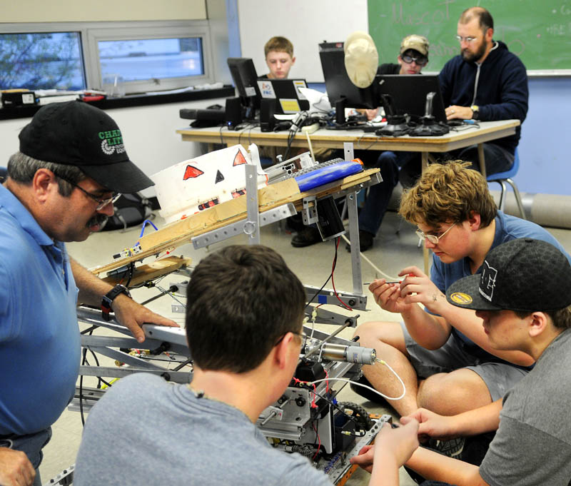 Members of the Gardiner Area High School robotics team work on their disc-shooting robot at the school in Gardiner on Sept. 10.