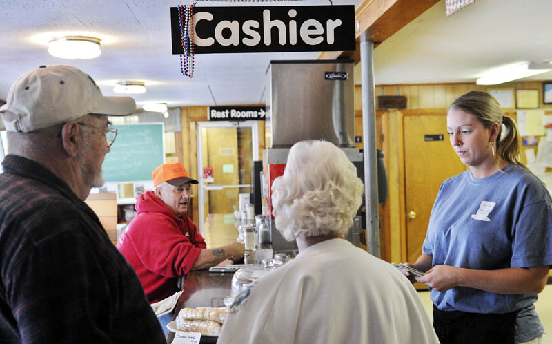 Hi-Hat waitress Caitlyn Laflin, right, gives customers change today on the eve of a meals, lodging and sales tax increases in Maine. Meals and lodging will increase from 7 percent to 8 percent and the sales tax will rise to 5.5 percent from 5 percent.