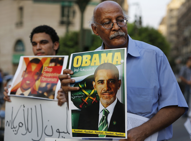 A demonstrator holds a placard mimicking U.S. President Barack Obama during a protest against possible U.S. forces' strike in Syria, in Cairo, Egypt, Sunday. The Arabic under Obama's name reads, "Legality first," and "Islamic, Islamic, Islamic, Islamic, Islamic," at the bottom. A top Syrian government official on Sunday dismissed the Obama administration as confused and hesitant, even as Secretary of State John Kerry said Washington has evidence of sarin gas use by Syria and that the case for a military attack is getting "stronger and stronger."