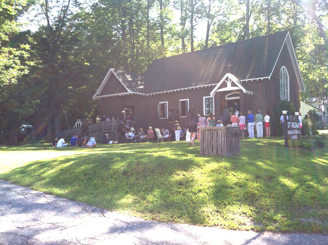 Parishioners often stand outside during Mass at St. Helena in Belgrade Lakes because the popular church draws more people than it can hold.