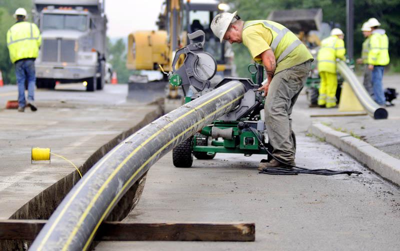 Workers with Bowdoin Excavation lay gas pipes in July in Augusta for Maine Natural Gas.