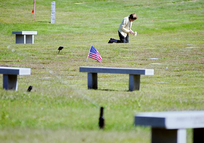 Betty Marchant places flowers Monday on the plots of her brother and sister-in-law at the Maine Veterans' Memorial Cemetery in Augusta. The New Jersey resident described the resting place for service members as "just beautiful."