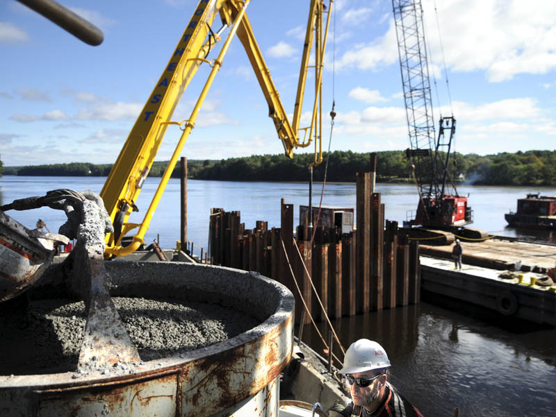 Workers with Reed & Reed mix and pour concrete Monday into a pier at the Richmond-Dresden Bridge construction project on the Kennebec River. Traffic on the old bridge was reduced to one lane to permit concrete trucks to stop and pour their loads into a mixer sitting over the edge, before pumping the mix into the pier that will support the new bridge. The 1,300-foot span over the river is expected to be completed by July 2015.