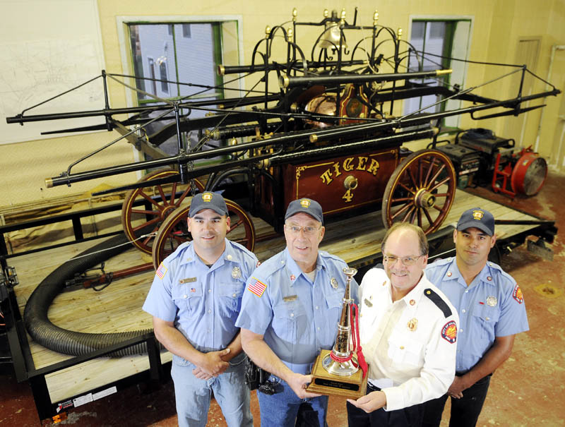Hallowell firefighters Lt. Roy Girard, left, Capt. Richard Clark, Chief Michael Grant and Ryan Girard display a trophy Wednesday that the volunteer company received Sept. 14, for exhibiting the department's Tiger engine at the 50th annual Maine State Federation of Firefighters Convention in Ellsworth. The 1836 fire pump was recognized by the federation during the convention's parade, Grant said, after the firefighters devoted several hours prepping it.
