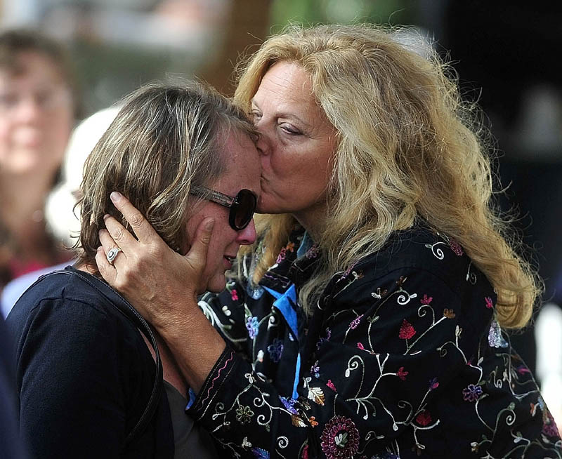 Andrea Ré, right, shares a moment with Jan Taylor during a celebration of her brother Bill Taylor's life at Castonguay Square in downtown Waterville today. More than 450 people attended to pay their respects.