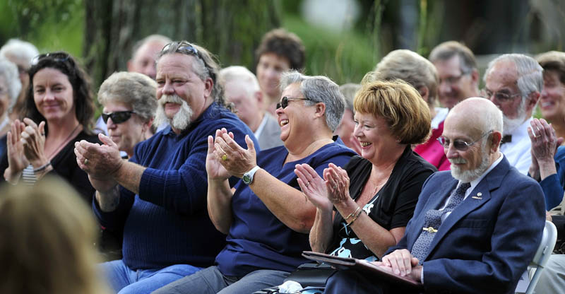 Cathy Taylor, widow of Bill Taylor, second from left, shares a laugh with 450 other friends of her late husband as they remember and celebrate his life at Castonguay Square in downtown Waterville today.