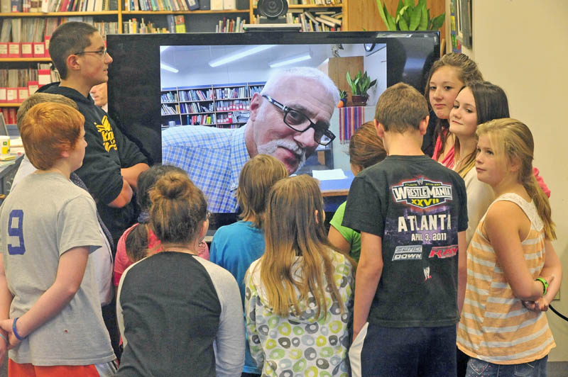Victor Esposito, the master specialist for the Jobs for Maine's Graduates program at Vassalboro Community School, interacts with his combined 6th and 7th grade class in the school's library on Thursday. Esposito spent the first week of the school year teaching via an iPad, while in the hospital with cellulitis in his left foot.