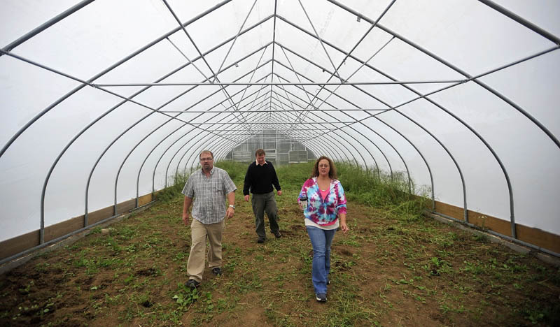 Jeff Chase, center, the agricultural specialist for the Maine School of Natural Sciences, offers a tour today to Mark Tulley, left, and Renee Gray, right, of one of three greenhouses recently erected at the Maine School of Natural Sciences in Hinckley.