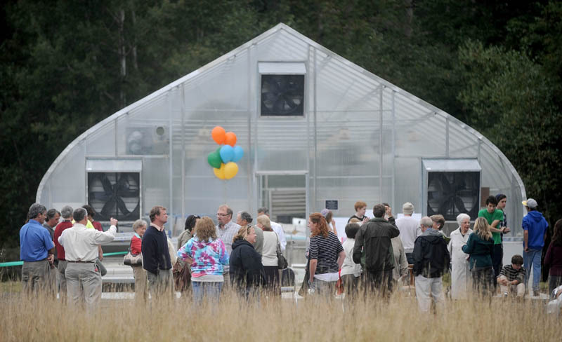 People gather around one of three newly erected greenhouses during their dedication at the Maine School of Natural Sciences in Hinckley today.