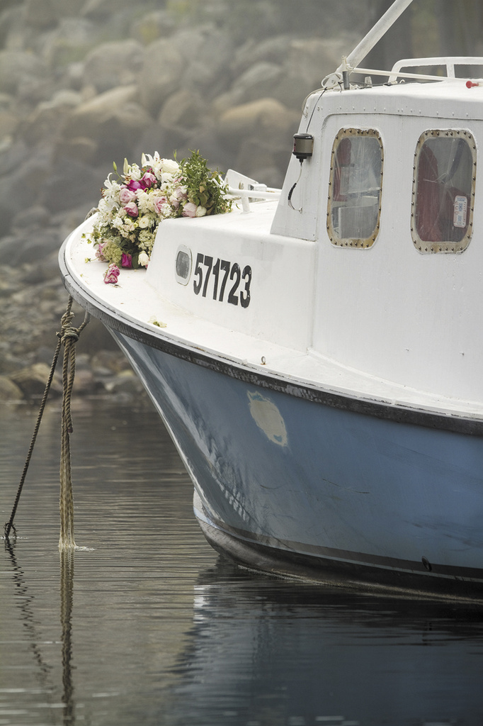 Bouquets of flowers are set on the bow of the lobster boat "Clover" in memorial of Billy McIntire in Perkins Cove on Wednesday, Aug. 28.