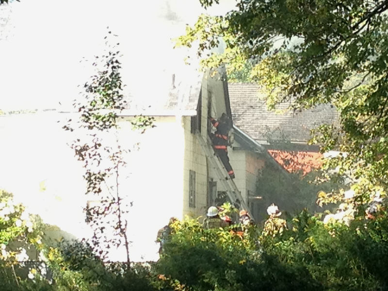Firefighters climb ladders into a Pittston home Friday afternoon after a fire was reported.