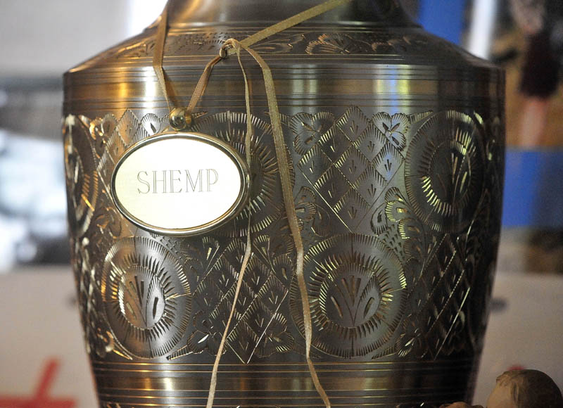 An urn containing the remains of Christopher Nelson and a tag displaying his nickname, "Shemp," rest on a television stand at the family's Pease Hill Road residence in Anson on Wednesday.
