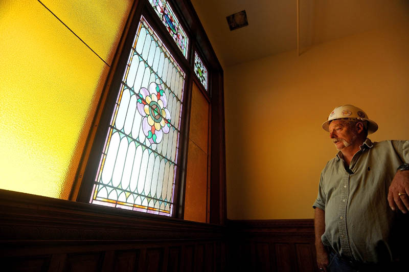 Homer Salisbury, site supervisor for Sheridan Construction, stands next to original, stained glass windows which illuminate the grand staircase in the Gerald Hotel in downtown Fairfield on Sept. 18.