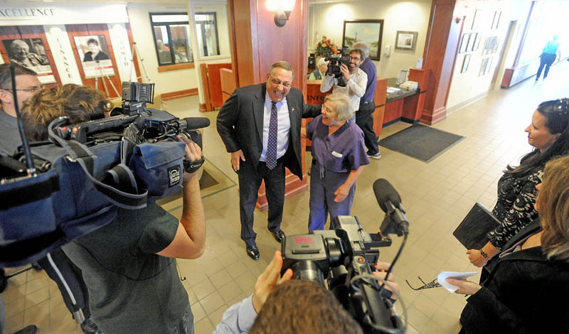 Gov. Paul LePage has a light moment with physician Joyce M. Stein in the lobby of Inland Hospital during a press conference in Waterville on Wednesday. LePage made the appearance to announce repayment of state MaineCare debt to Maine's 39 hospitals, including $9.5 million to Inland Hospital.