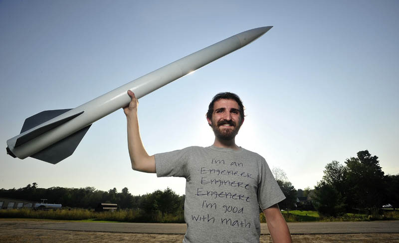 Michael Ostromecky, 22, of Winslow, and six colleagues are planning to launch an 18-foot rocket to about 180,000 feet into the atmosphere next week. He designed the five-foot rocket he is holding and it reached 2,000 feet.