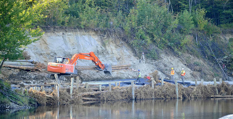 Constructions crews work on the eroded banks of the Sandy River near Whittier Road in Farmington today.