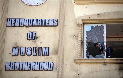 In this July 1, 2013, photo, an Egyptian protester ransacks the Muslim Brotherhood headquarters in the Muqatam district in Cairo.
