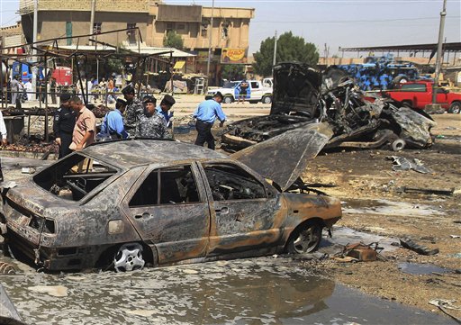 Iraqi security forces inspect the site of a car bomb attack in Basra Sunday.