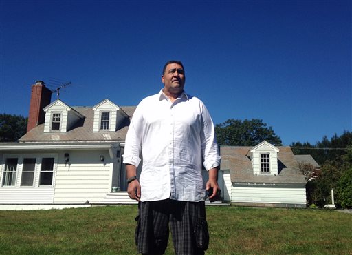 Former NFL offensive lineman Brian Holloway stands in front of his rural vacation home on Wednesday in Stephentown, N.Y.
