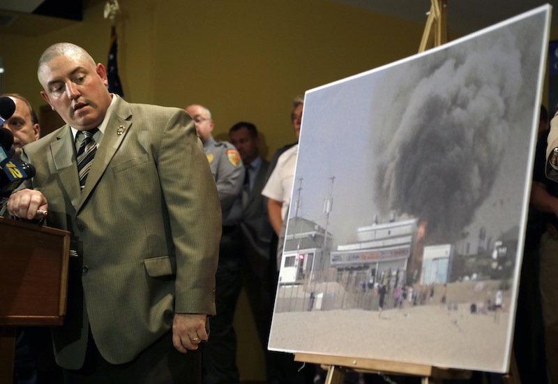 Ocean County prosecutors office arson investigator Thomas Haskell Jr., uses a laser-pointer on a photograph of a fire that started last Thursday near a frozen custard stand on the boardwalk in Seaside Park, during a news conference in Toms River, N.J., Tuesday, Sept. 17, 2013 Authorities said the massive boardwalk fire was accidental and linked it to electrical wiring and equipment that was compromised by Superstorm Sandy nearly a year ago. Investigators say the fire, which destroyed more than 50 boardwalk businesses, started under a building that housed a candy store and an ice cream stand. (AP Photo/Mel Evans)