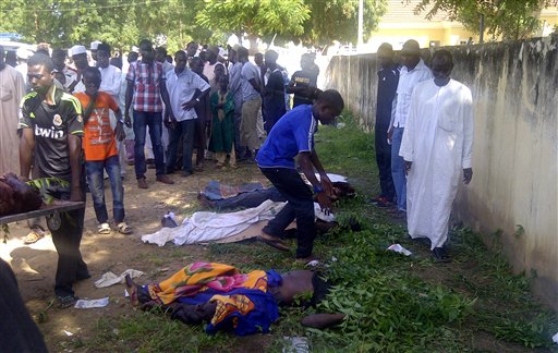 In this image taken with a mobile phone, rescue workers and family members gather to identify the shrouded bodies of students killed following an attack by suspected Islamist extremists on an agricultural college in Gujba, Nigeria, on Sunday.