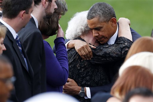 President Obama comforts a woman sitting in the family section at a memorial service Sunday for the victims of the Washington Navy Yard shooting.