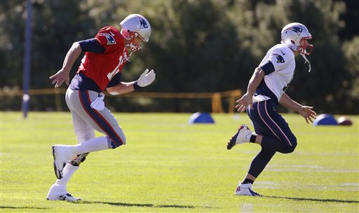 New England Patriots quarterback Tom Brady, left, and wide receiver Julian Edelman run across the field during a stretching and drills session before practice at the team's training facility in Foxborough, Mass., Wednesday.