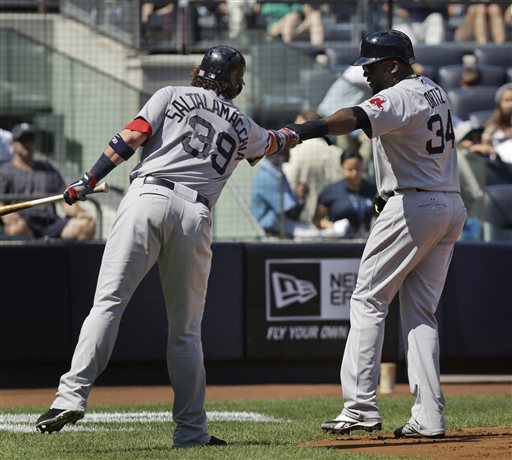 IT’S ON: Boston Red Sox’s David Ortiz, right, celebrates with teammate Jarrod Saltalamacchia after scoring on double hit by Mike Carp on Sunday against the New York Yankees in New York. The Red Sox open a key series with the Tampa Bay Rays tonight.