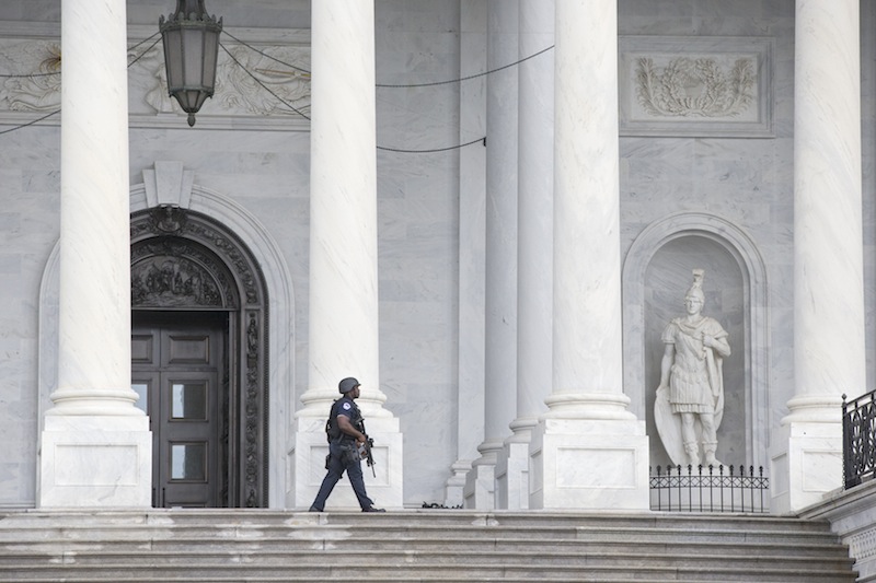 U.S. Capitol Police personnel keep watch on the East Plaza of the Capitol as the investigation continues at the nearby high-security Washington Navy Yard where gunmen went on a shooting rampage, Monday, Sept. 16, 2013, in Washington. (AP Photo/J. Scott Applewhite)